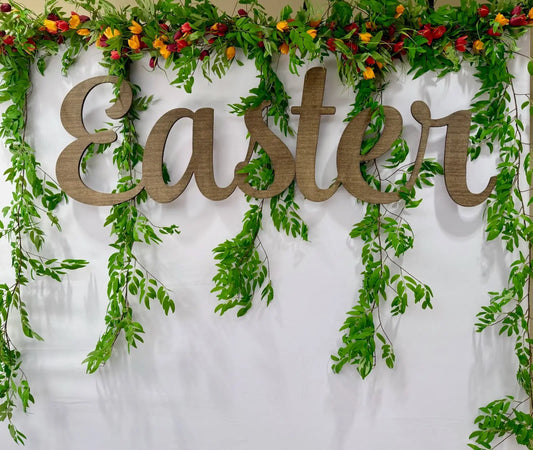 Wooden “Easter” lettering displayed on a white wall with lush greenery and spring flowers, capturing the essence of spring freshness. A joyful backdrop for church photo dates or seasonal events. Find a variety of Easter items from this trusted seller. Apply filters to sort and choose the style that makes everyone happy.