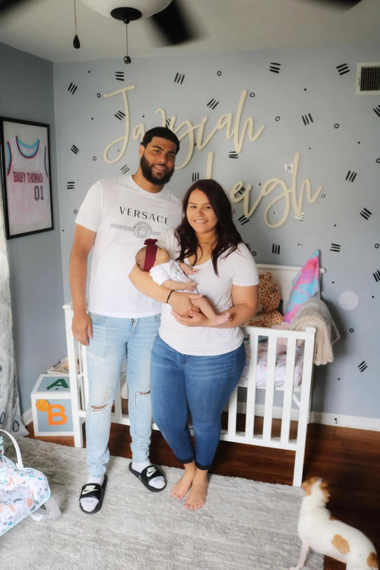 Jayviah Leigh nursery wall letters with parents and baby.