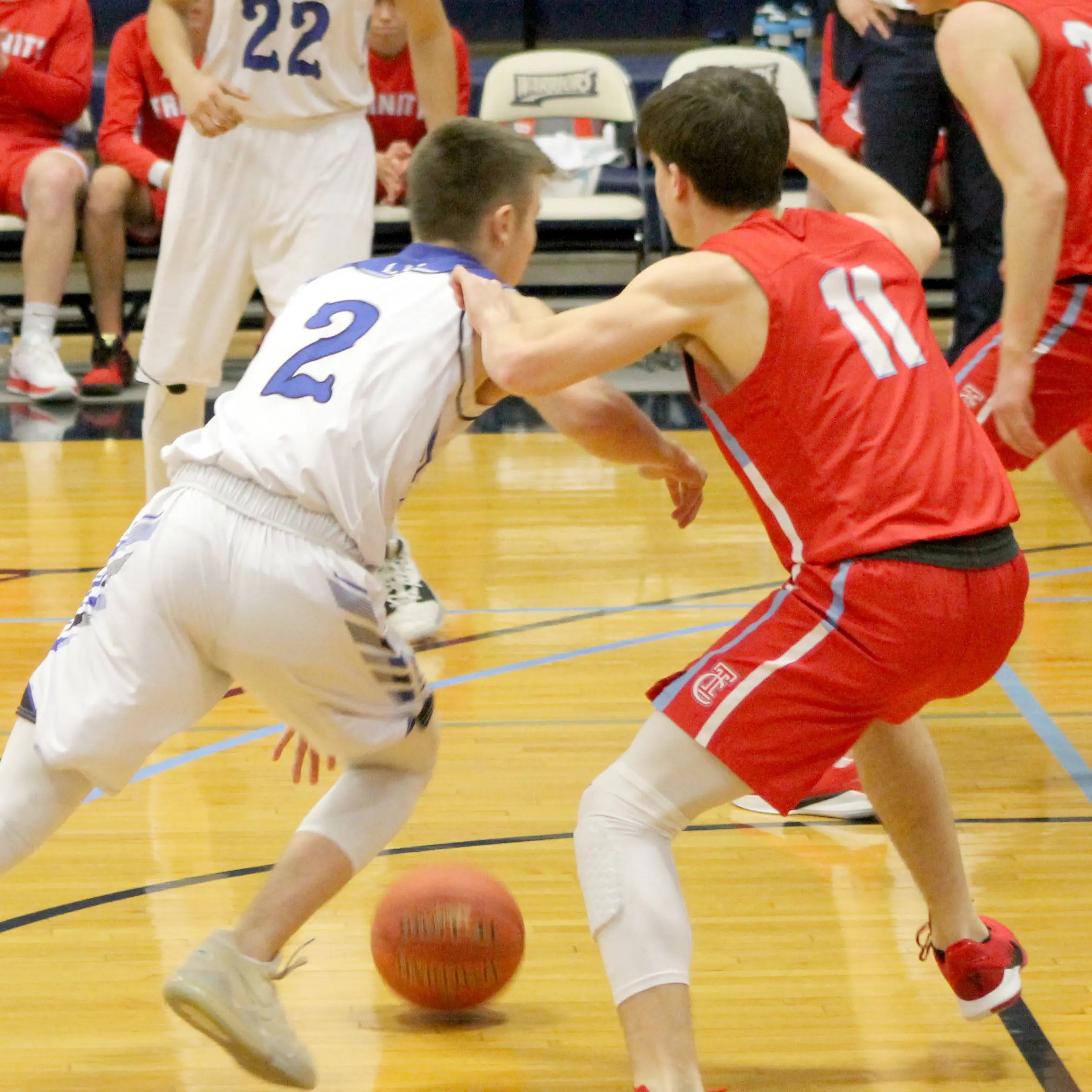 Basketball Senior Night Gift ideas From Collage and Wood. Picture is of a basketball player in white jersey dribbling while a player in a red jersey plays defense.