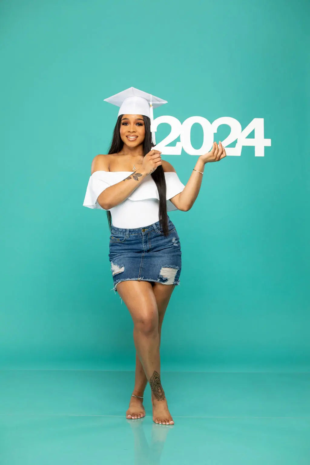 2024 senior Picture props. Beautiful grad with cap and tassel holding 2024.