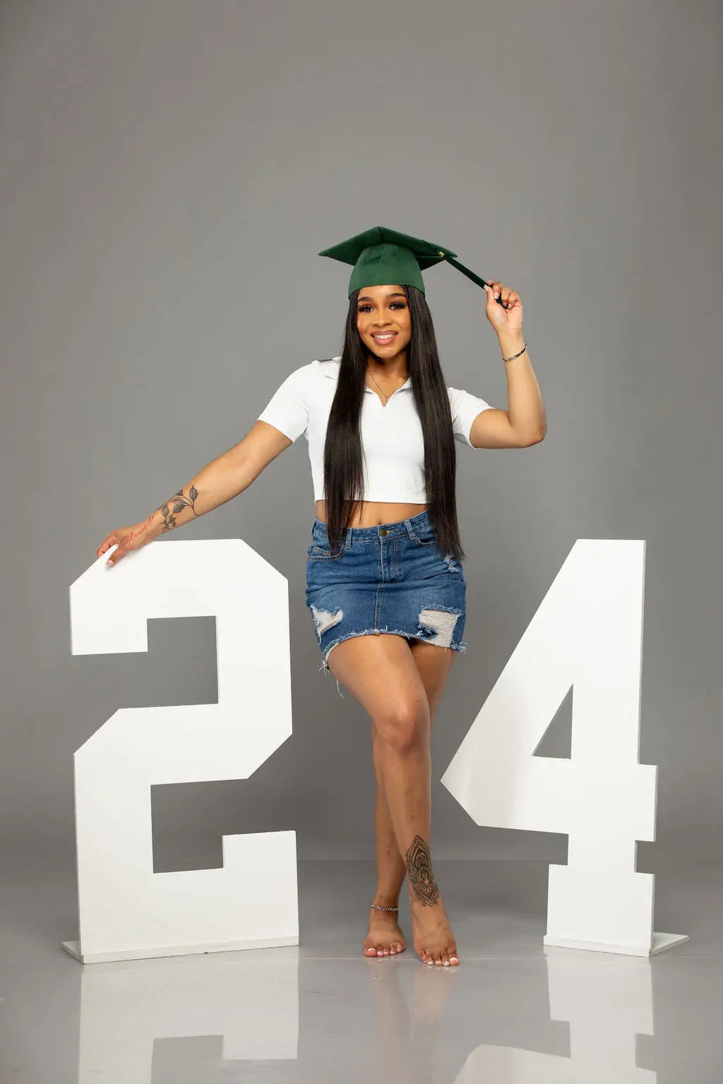 A beaming graduate model making her graduation year memorable with a 2024 wooden photo prop from Collage and Wood.