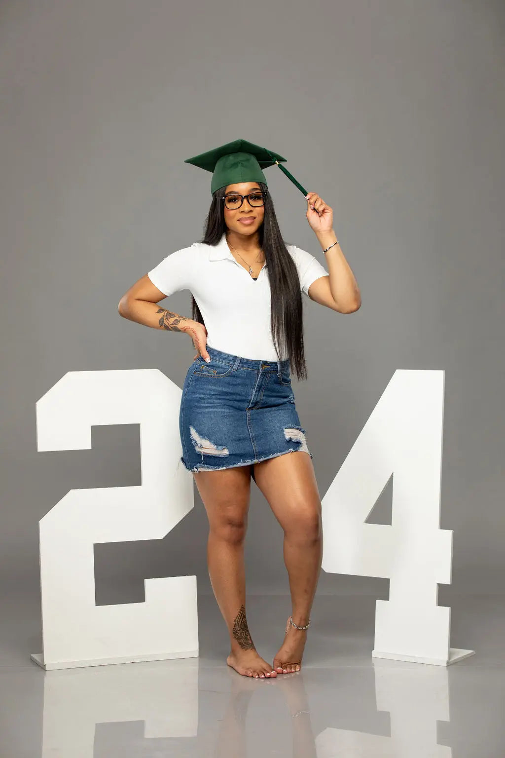 Graduate model proudly displaying her graduation year with a 2024 wood photo prop created by Collage and Wood.