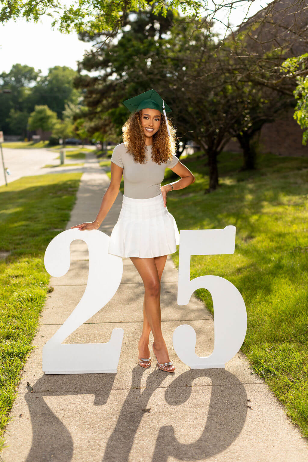 graduation model standing between two giant white numbers: 25.