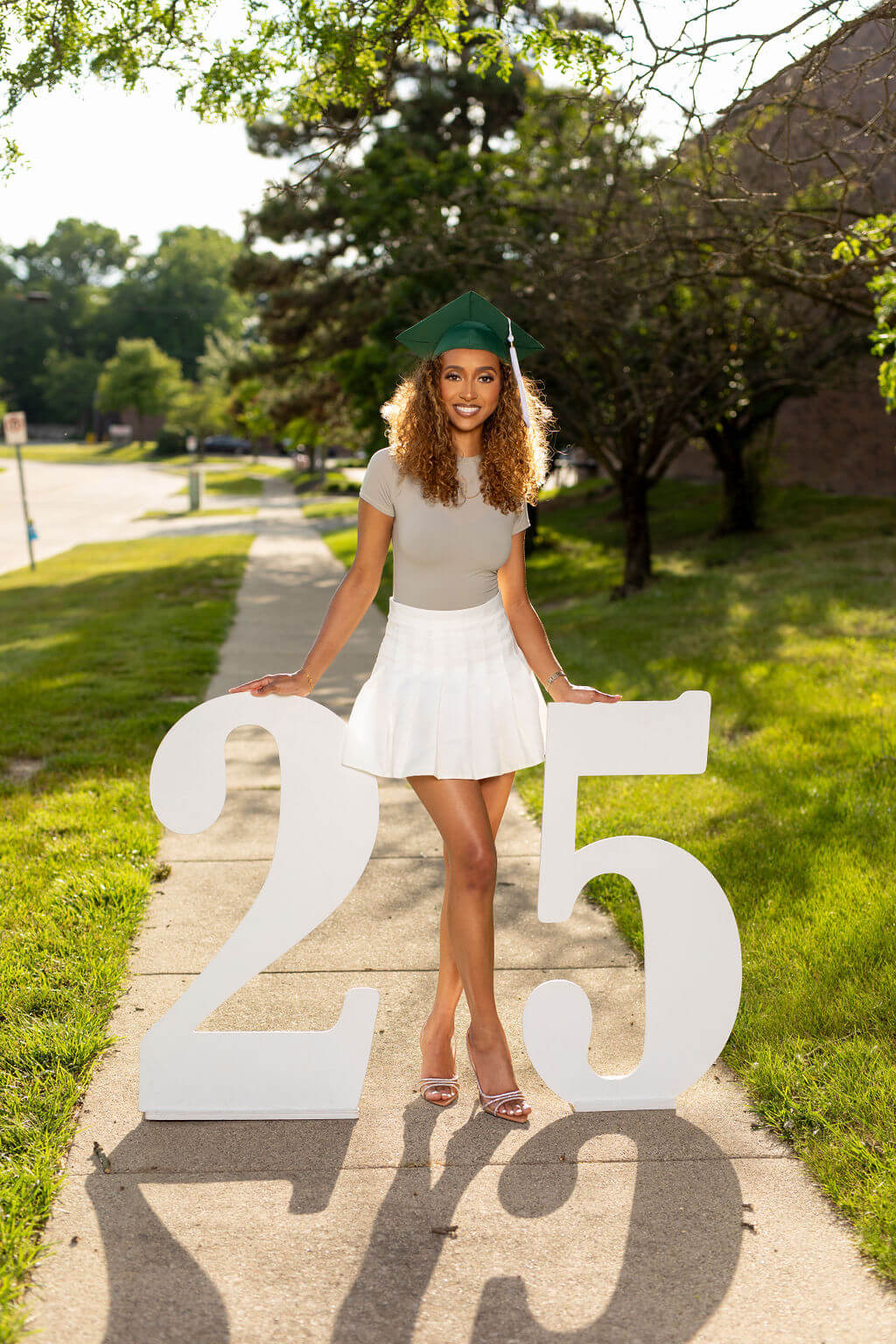 graduation model standing between two giant white numbers: 25.