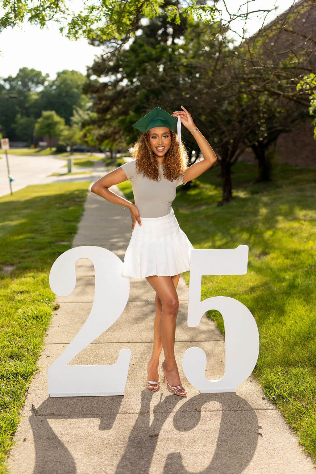 graduation model standing between two giant white numbers: 25.