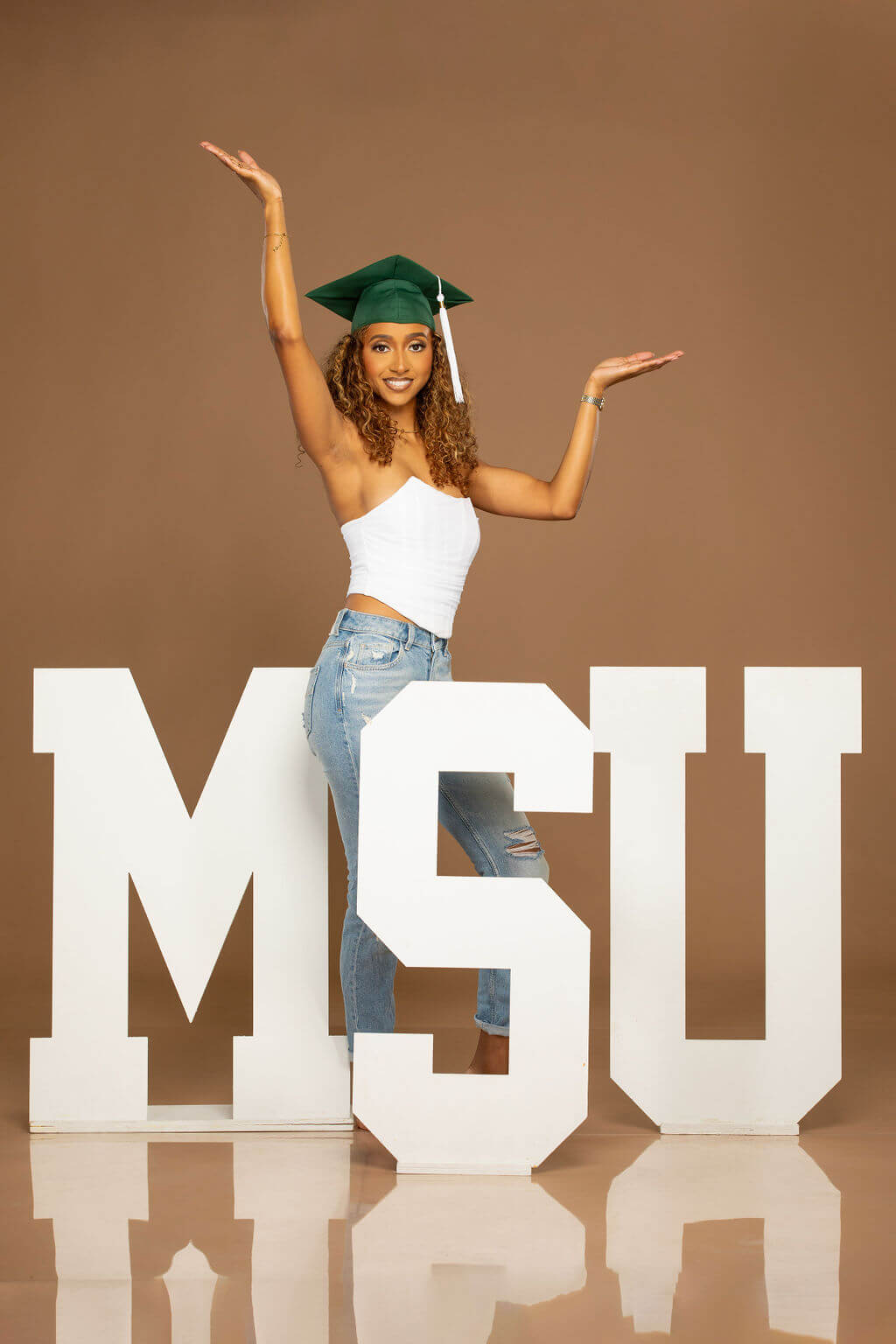 senior model posing with MSU wooden letters.