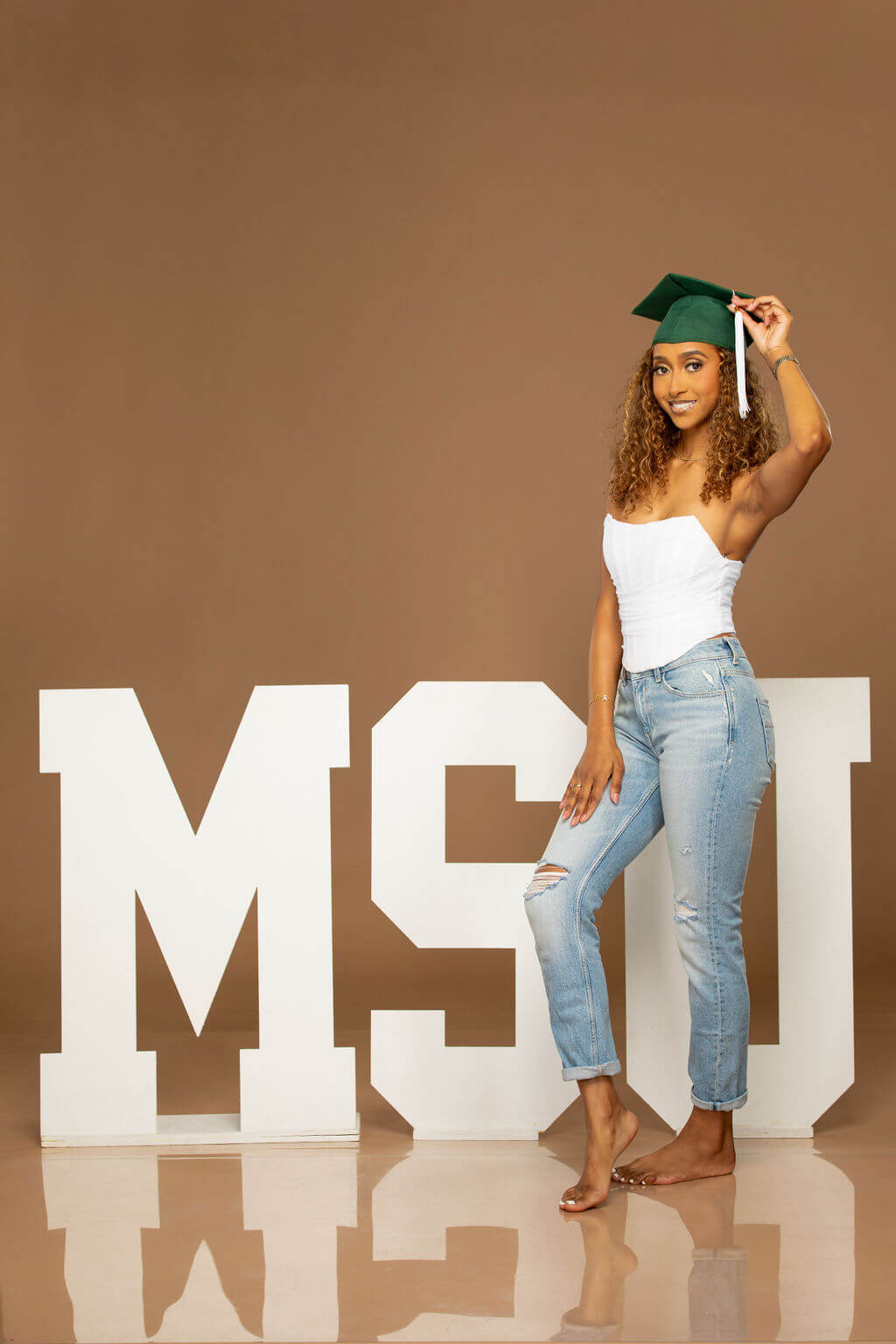 senior model posing with MSU wooden letters.