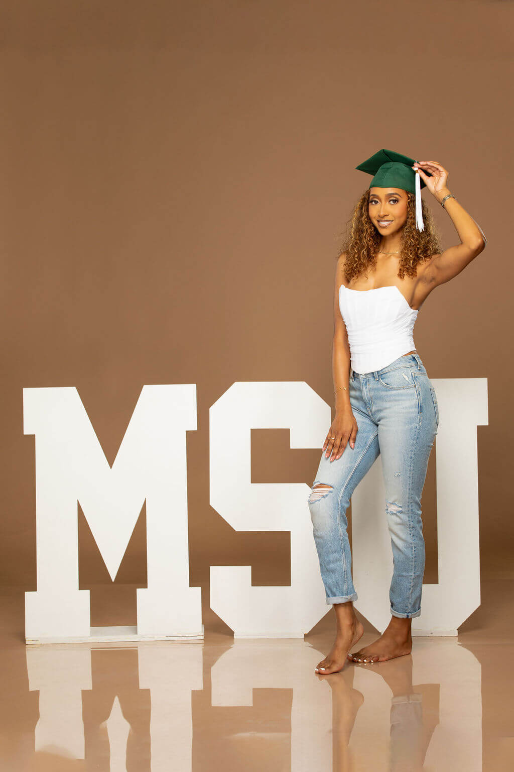 senior model posing with MSU wooden letters.