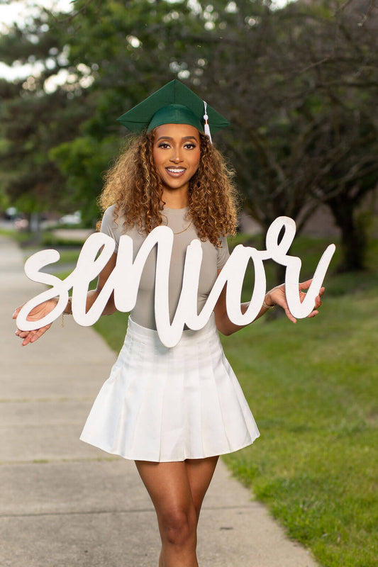 Senior Model is holding a white 36 inch photo prop that says "senior!"