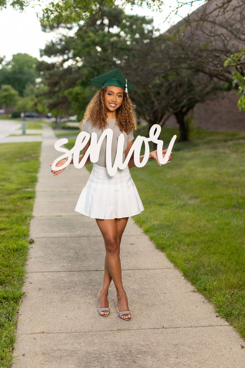 Senior Model is holding a white 36 inch photo prop that says "senior!"