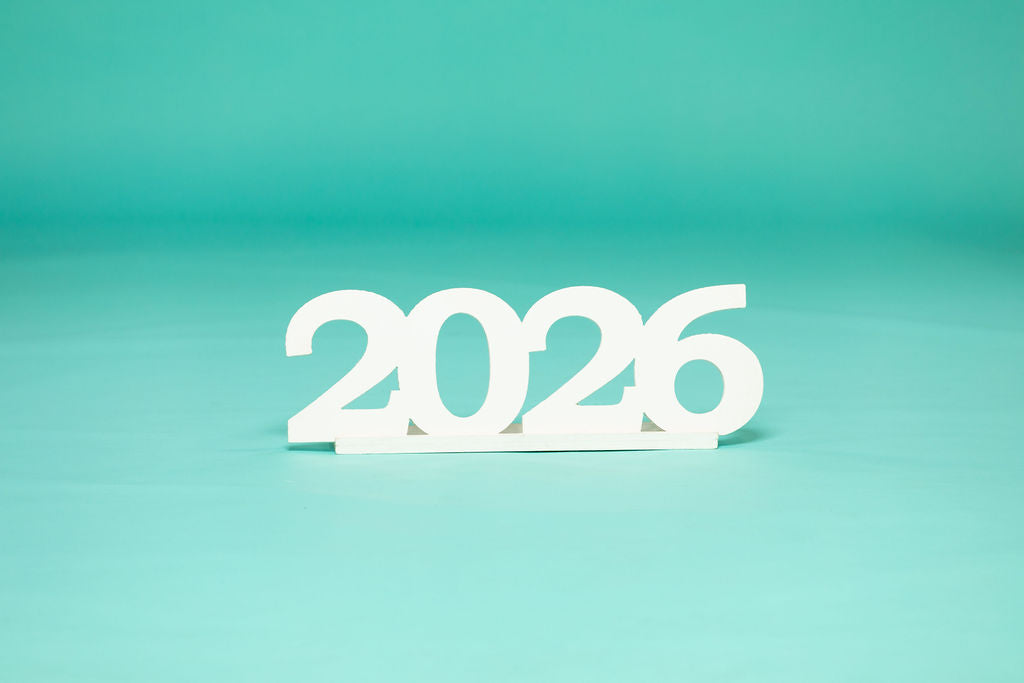 Studio display of white “2026” numbers centered against a teal backdrop. 2026 senior props available now at collageandwood.com