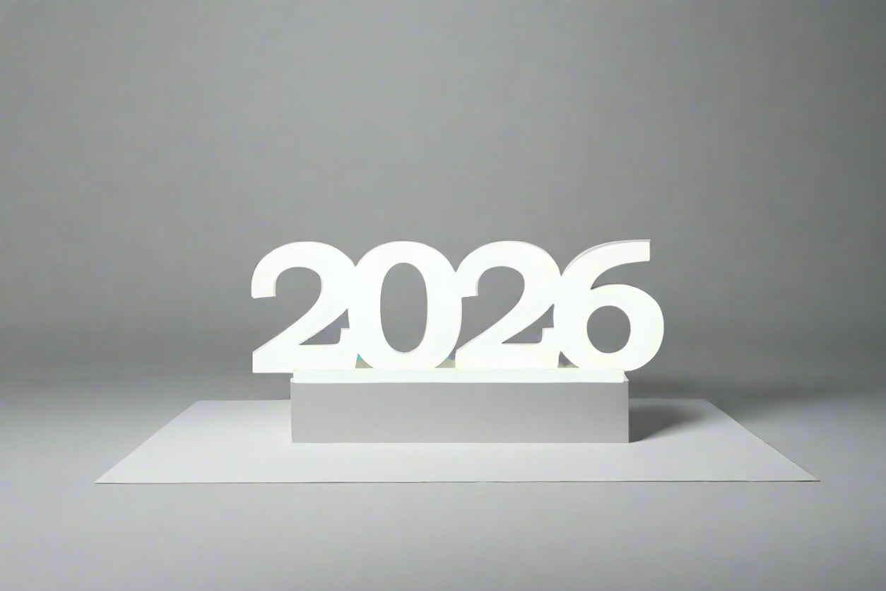 Close-up of a white wooden “2026” tabletop sign on a gray background, perfect for graduation décor and photo ops. 