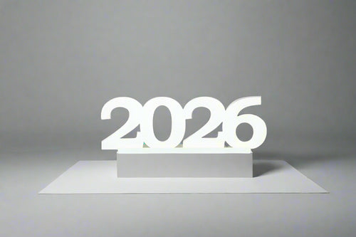 Close-up of a white wooden “2026” tabletop sign on a gray background, perfect for graduation décor and photo ops. 