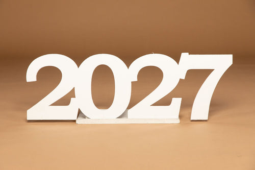 White 3D wooden numbers '2027' standing on a small matching base against a warm brown background. Available at collageandwood.com.