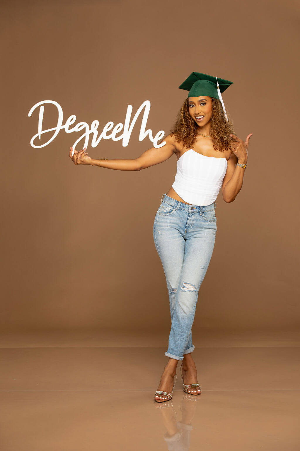 Degree Me Photo Prop, Held by senior model in grad cap indoors in professional photography studio.