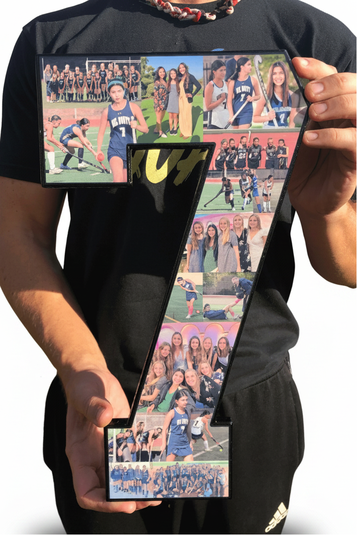 A custom field hockey gift for #7, a custom collage made in the shape of a 7 by Collageandood.com. Held by a man, Jon Waddell in a a black shirt and black pants.