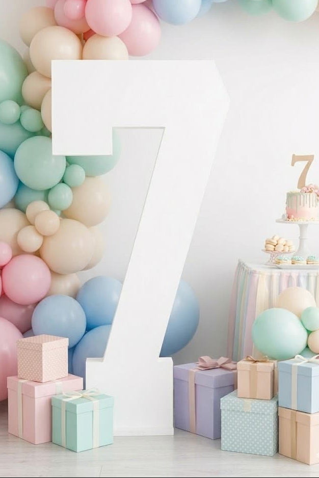 Pastel-colored balloons and gift boxes with a giant wooden number 7 from collageandwood.com.