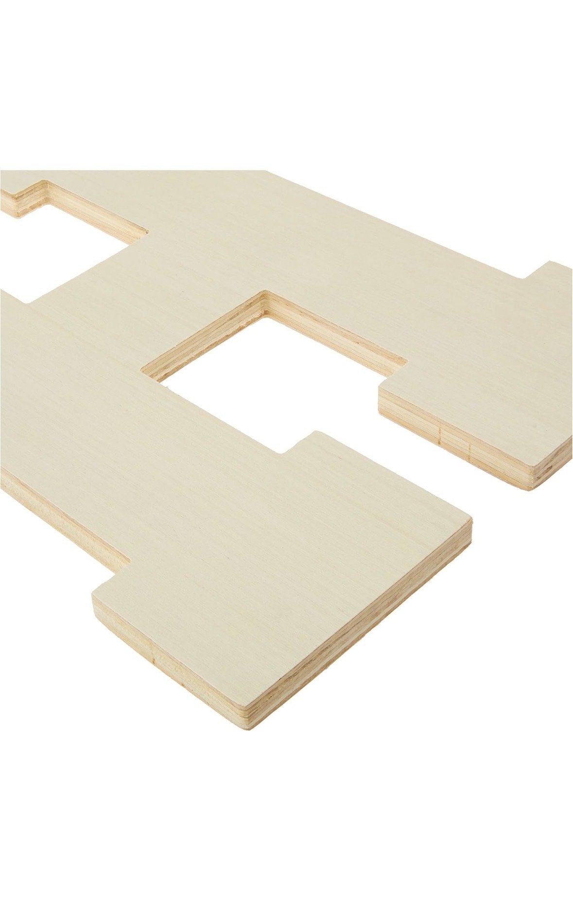 Close-up of a CNC-cut 1/2-inch plywood letter H showing the smooth sanded face and layered plywood edge
