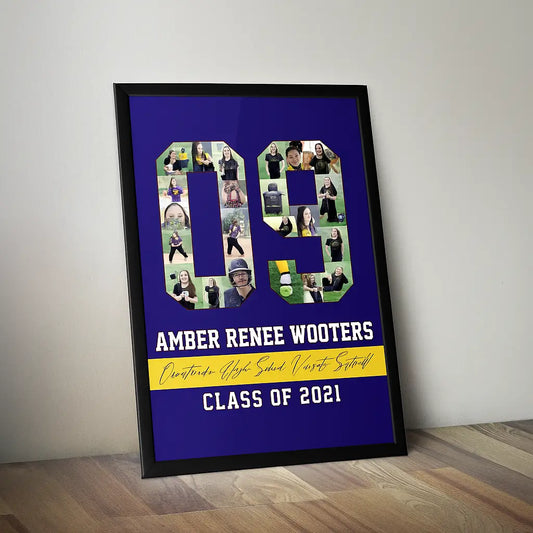 A custom graduation poster designed by Collage and Wood, featuring the name "Amber Renee Wooters" with a collage of softball photos forming the number "09." The poster includes the text "Orestano High School Varsity Softball" and "Class of 2021" on a deep blue background, all framed in a sleek black frame and displayed against a light gray wall on a wooden floor.