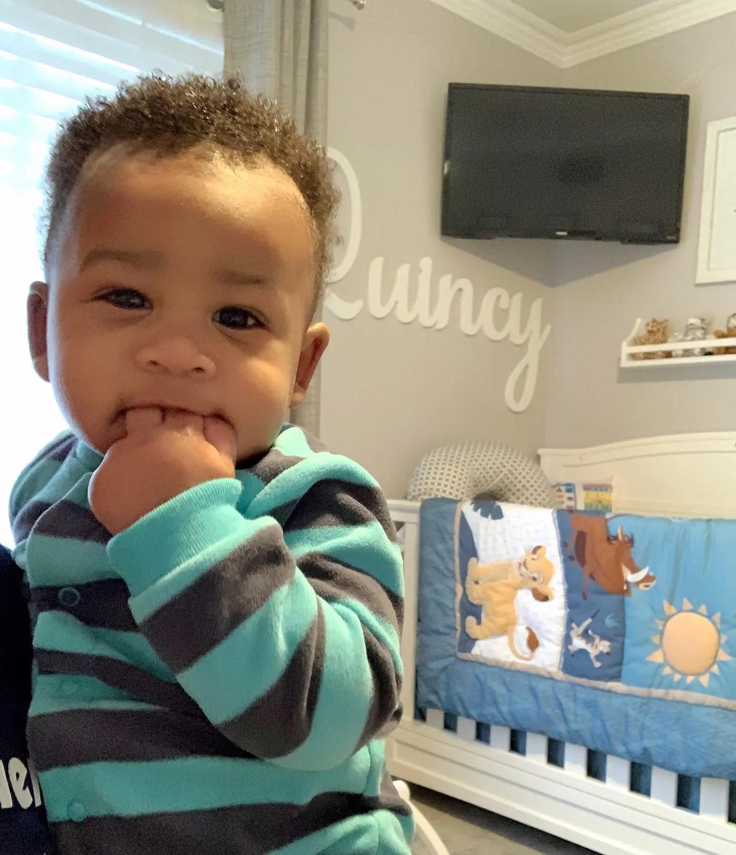Quincy in his nursery in front of his wall letters.