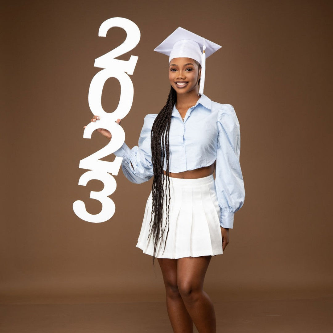2023 senior photo props, held by graduate in white and blue